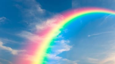 Image of a rainbow arching across a blue sky