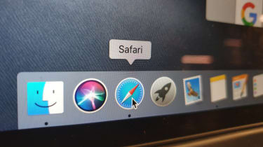 A mouse hovering over the Safari logo on a MacBook