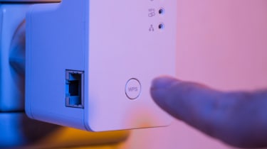 WPS button being pushed on a Wi-Fi extender