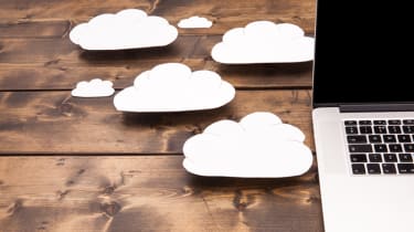 Pictures of white clouds on a desk besides a laptop 
