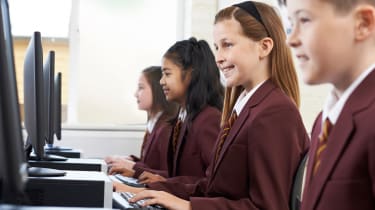 A group of schoolchildren working on PCs