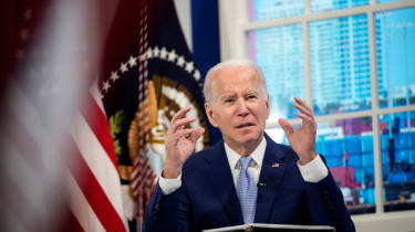 US president Joe Biden speaking to press at the White House while sat in front of the US flag
