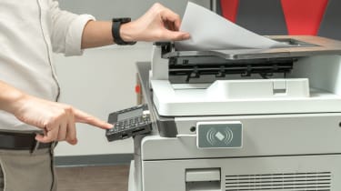 An office worker using a large printer