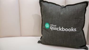 A cushion on a sofa with Intuit&#039;s Quickbooks logo branded onto it 
