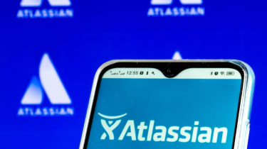 Atlassian logo on a smartphone, with the logo on a wall in the background too