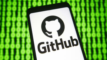 GitHub logo displayed on a smartphone in front of a mocked-up binary code background