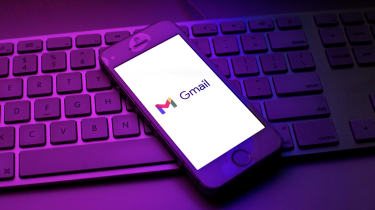 A smartphone on a keyboard showing the Gmail loading screen