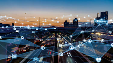 A city skyline at dusk overlaid with graphics to show an IoT network